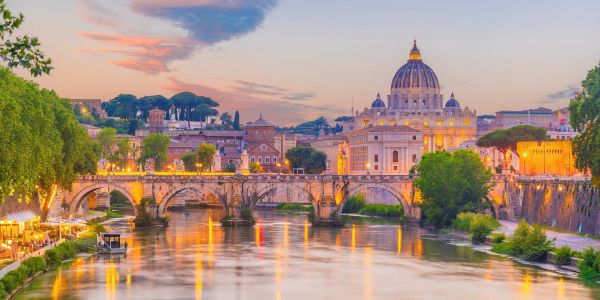 Scenic view of a historic bridge and cathedral at sunset.