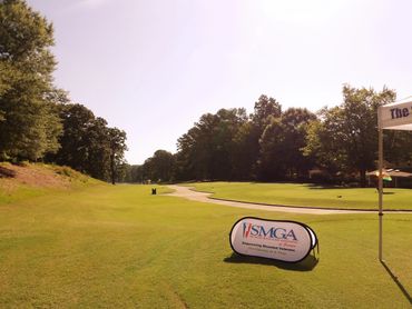 Golf course with SMGA sign and flag.