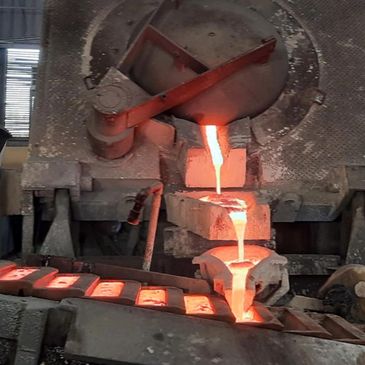 Molten metal pouring into molds in a foundry.