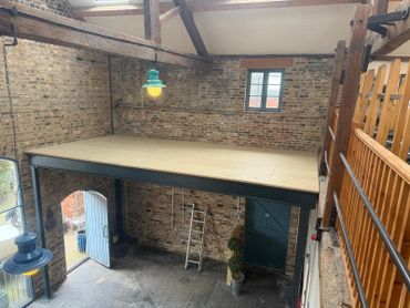 Industrial loft space with exposed brick walls and wooden beams.