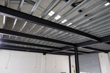 Steel beams and metal decking forming a building's ceiling framework.