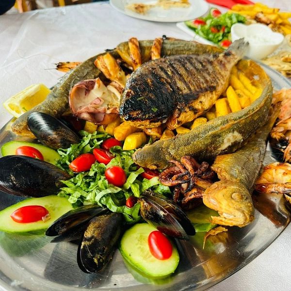 Seafood platter with grilled fish, shellfish, and vegetables.