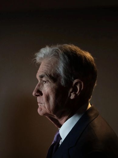Profile portrait of an elderly man in a suit against a dark background.