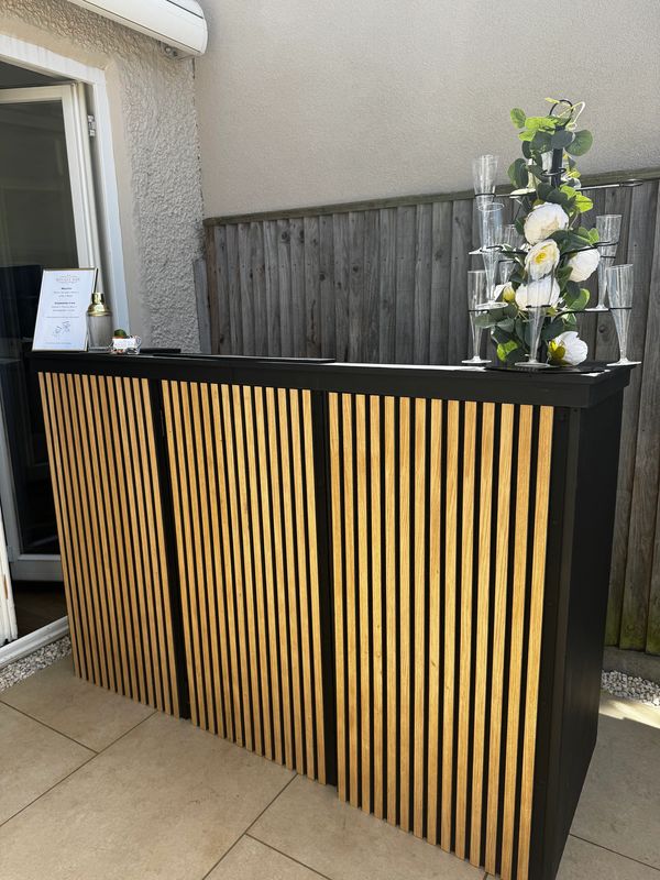 Modern wooden outdoor bar with floral decoration.