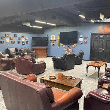 Cozy lounge with leather chairs and TVs.