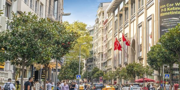 Tree-lined street with historic buildings and Turkish flags in Nişantaşı, Istanbul