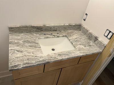 Newly installed granite bathroom countertop with a built-in sink.