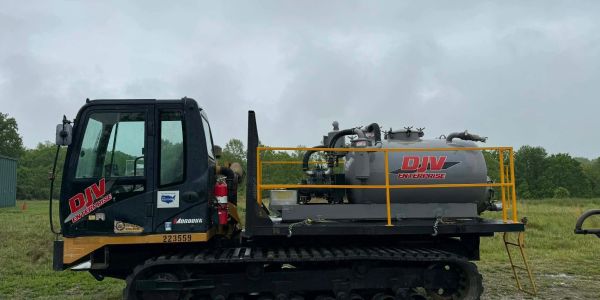 Tracked industrial vacuum truck by DJV Enterprise on a cloudy day.