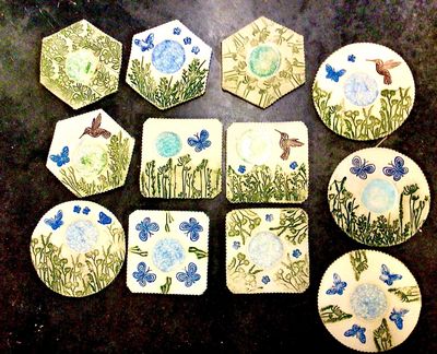 Hand-painted ceramic coasters with nature designs.
