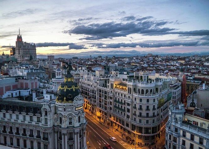 Sunset view over Madrid's iconic Gran Via with Metropolis building in foreground.