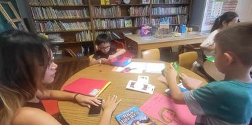 Children and a teacher engaging in a craft activity in a library.