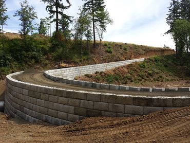 Curved retaining wall along a hillside dirt path.