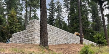 Stone retaining wall in a forested area.