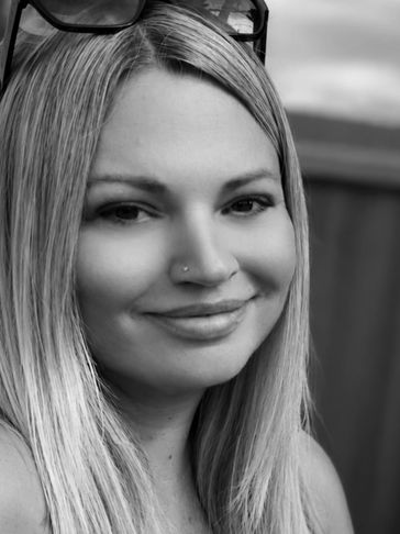 Black and white close-up portrait of a smiling woman.