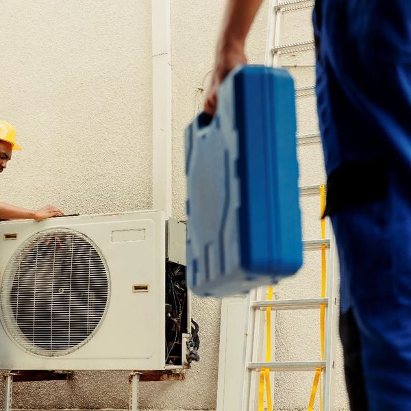 Technicians performing AC Repair in Andover by servicing an outdoor air conditioner for reliable sum