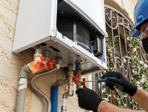 Technician performing Heating Repair in Fridley by adjusting valves and servicing residential heatin