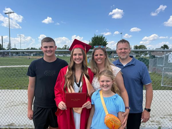 Family celebrating a graduation outdoors.