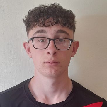 Young man with glasses and curly hair wearing a sporty Nike shirt.