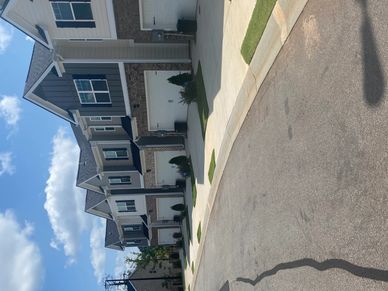 Driveways with green patches in front of garage doors in a residential area.