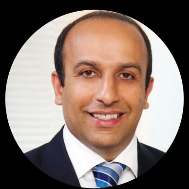 Professional man smiling in suit and striped tie.