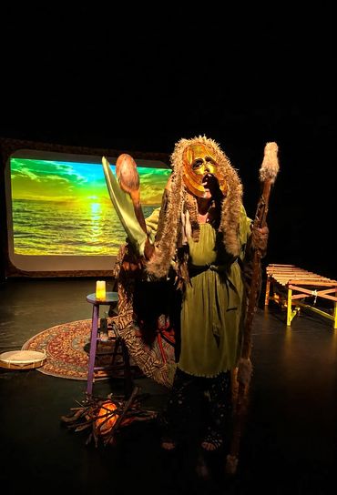 Person in tribal costume performing on stage.