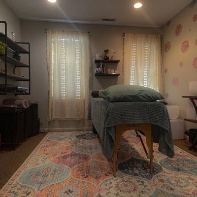 Cozy massage room with soft lighting and rustic decor.