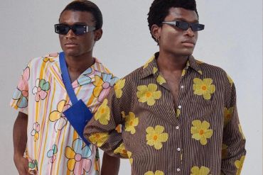 Two men wearing floral print shirts and sunglasses.