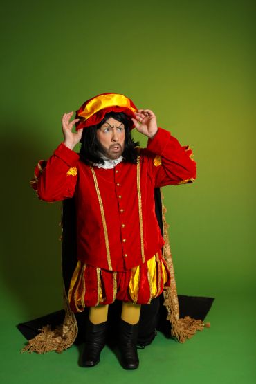 Man in colorful medieval costume against green background.
