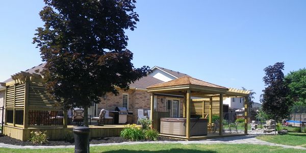 A beautiful deck with covered hot tub, privacy louvres and flagstone walk