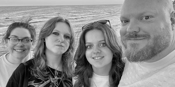 Group selfie with ocean in background.