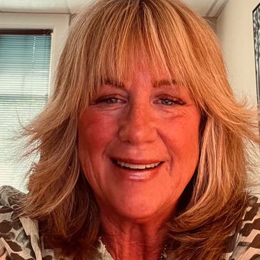 Smiling woman with blonde hair in a bright room.
