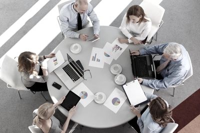 Business team reviewing charts and data around a conference table.