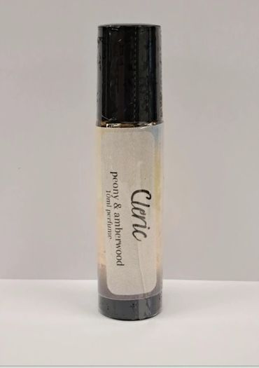 A small perfume bottle labeled Cleric with peony &amp; amberwood scent.