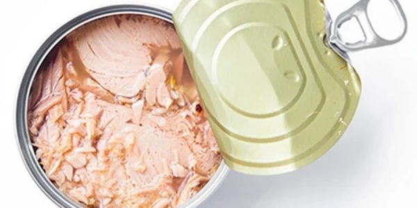 Opened can of pink tuna chunks with a pull-tab lid.