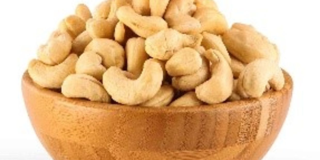 A wooden bowl filled with raw cashew nuts.