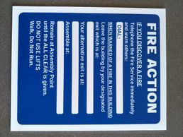 A fire action sign in blue with white writing.
