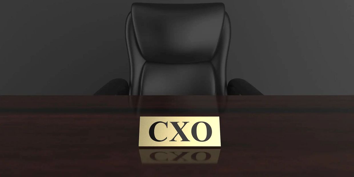 A CXO nameplate placed on a desk in front of an executive chair, symbolizing leadership authority, decision responsibility, and strategic oversight. The image reflects founder-level leadership, executive decision-making, and the role of structured governance in driving business stability, operational clarity, and performance alignment in complex industries such as jewellery manufacturing and healthcare.