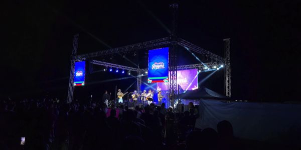 Actuación musical en directo sobre un escenario exterior iluminado por la noche.