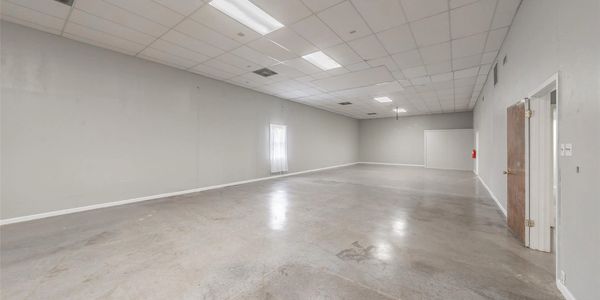 Empty large room with gray walls and concrete floor.