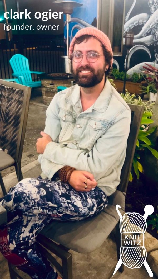 founder, owner, clark ogier, sitting in a chair smiling, wearing a knit witz beanie, with knit witz 
