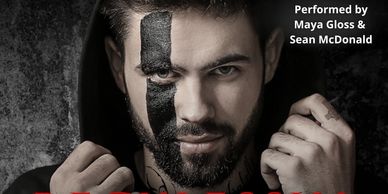Man with black face paint and a hood, intense gaze.