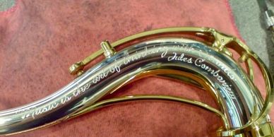Hand engraved lettering on a silver saxophone neck