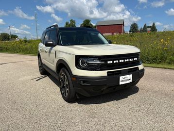 White Ford Bronco SUV parked on the road.