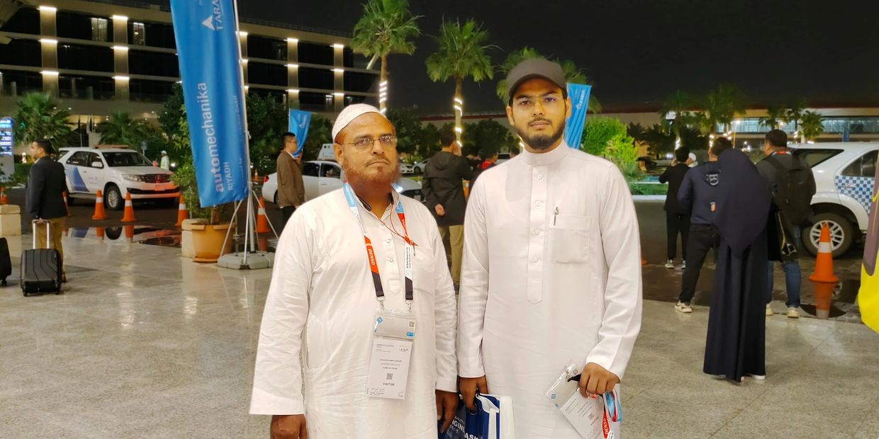 Two men in white traditional clothing at night.