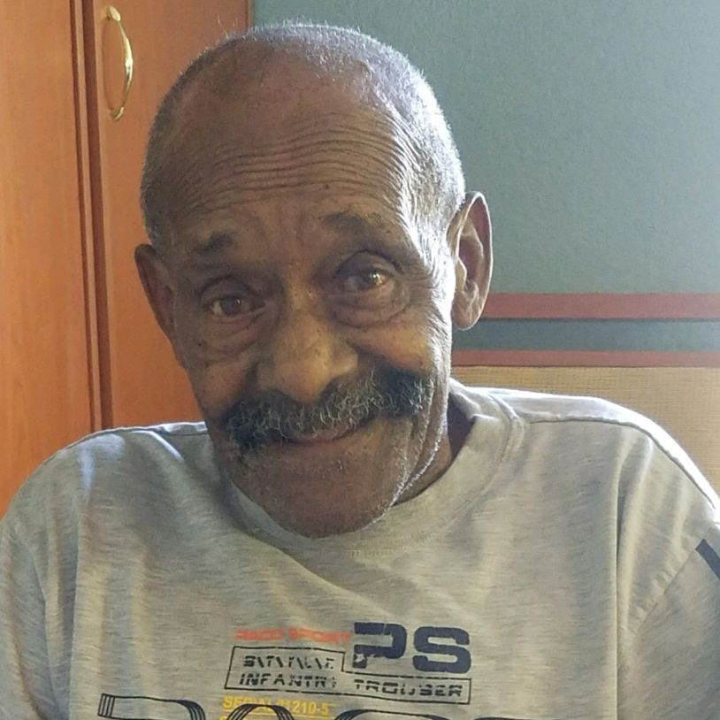 Smiling elderly man with a mustache.