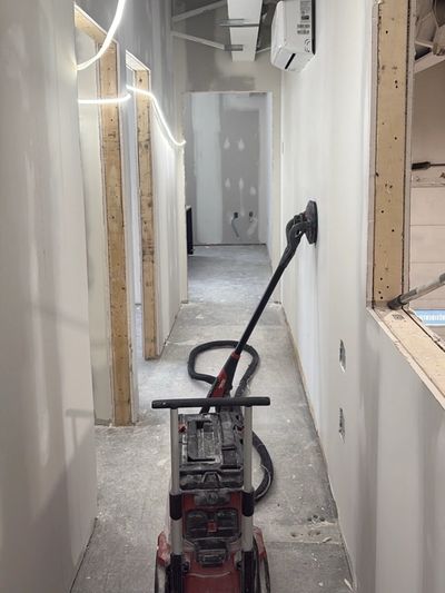 Vacuum cleaner in a narrow hallway under construction or renovation.