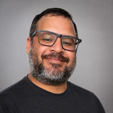 Smiling man with glasses and a beard.