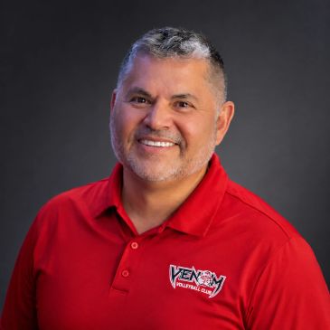 Smiling man in red Venom Volleyball Club polo.