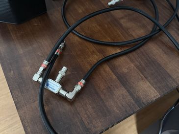 Coaxial cables connected to a splitter on a wooden desk.