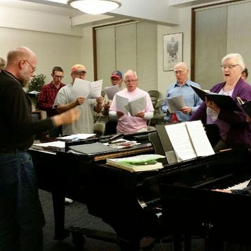 Director Bill Tuzicka rehearses the tenors and basses of the Salina Chorale in a breakout session
